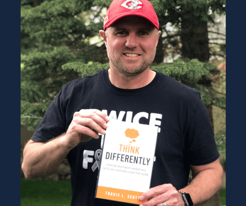 Travis holding his book Think Differently - Blog Image