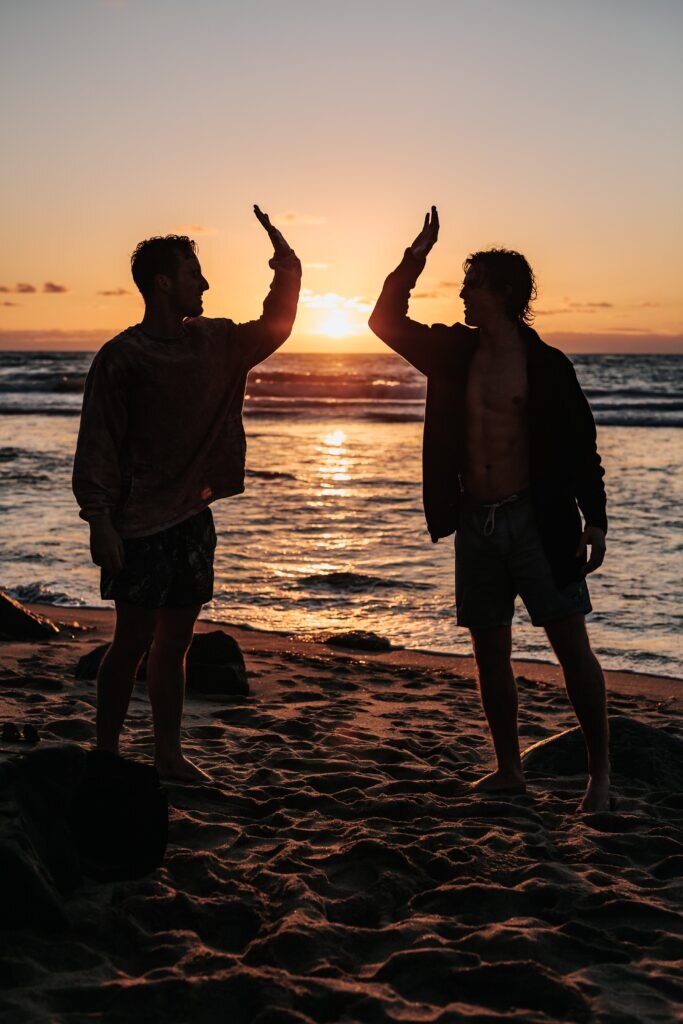high five on a beach at sunset
